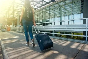 pexels-photo-1008155-1008155 Woman Walking on Pathway While Strolling Luggage